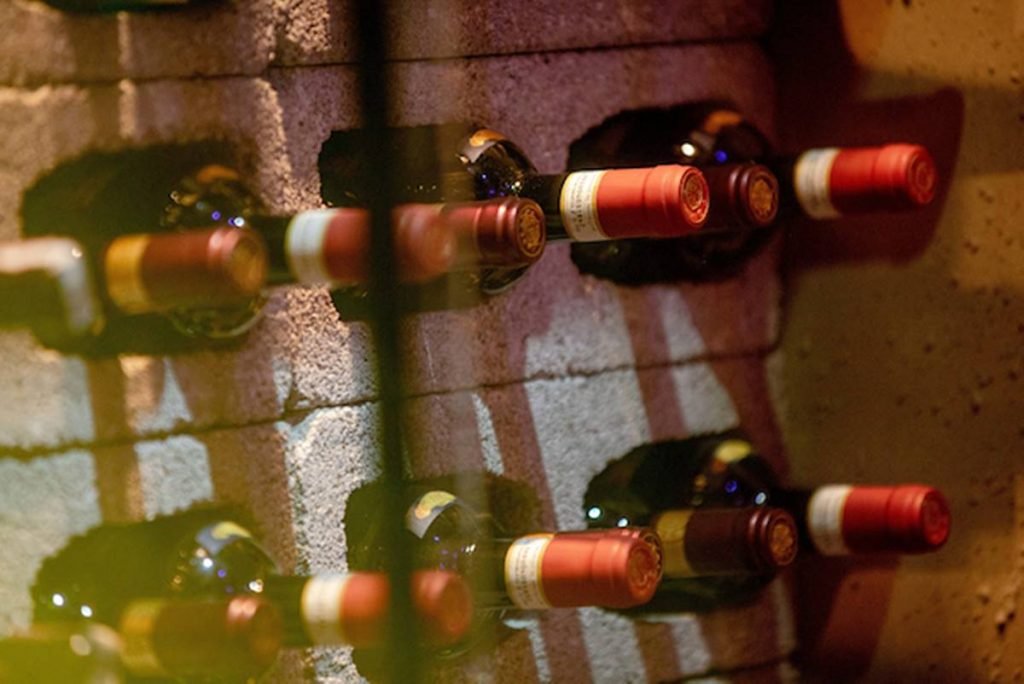 foto de uma parede com diversas garrafas de vinho