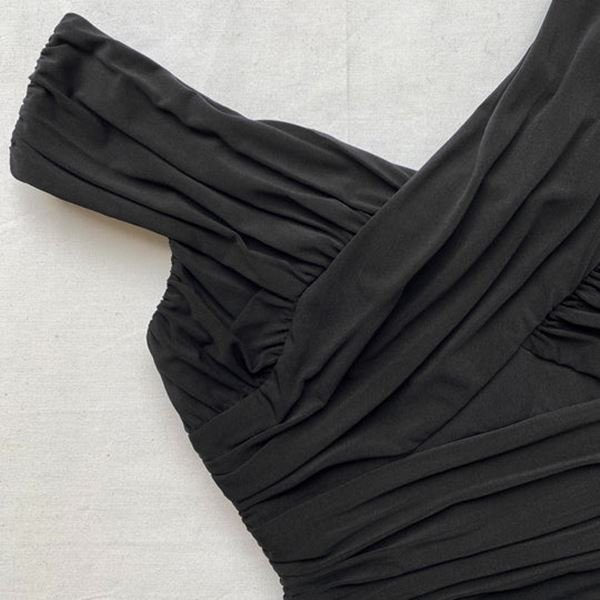Detalhe de vestido preto em fundo branco
