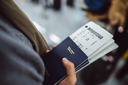 mulher segurando passaporte com passagem aérea