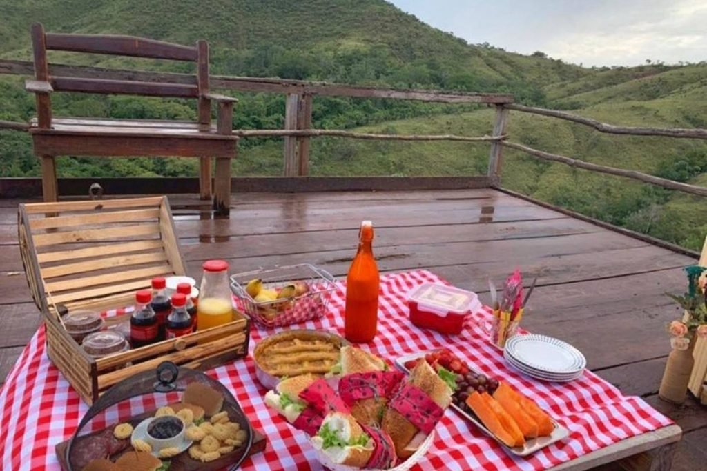 na foto vemos uma machadinha ao fundo com varias comidas e montanhas