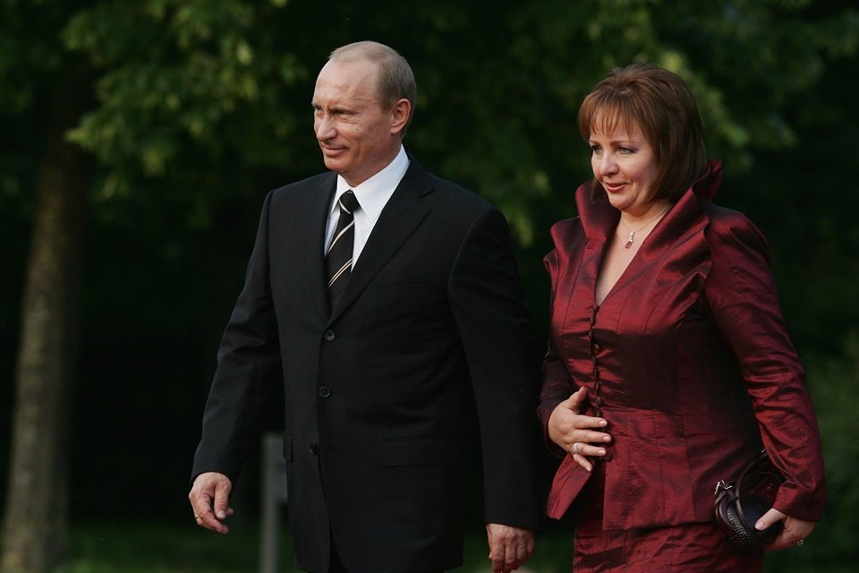 Vladimir Putin, de terno, ao lado de sua ex-mulher, Lyudmilla Putina, que usa roupa vermelha-escura - Metrópoles