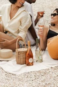 Três mulheres bebendo vinho em um piquenique