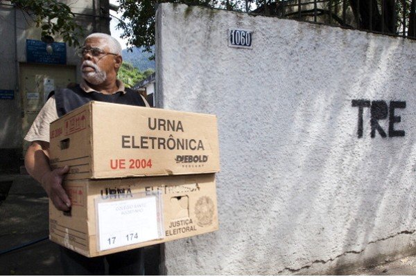Homem carrega caixas de papelão com urna eletrônica-Metrópoles