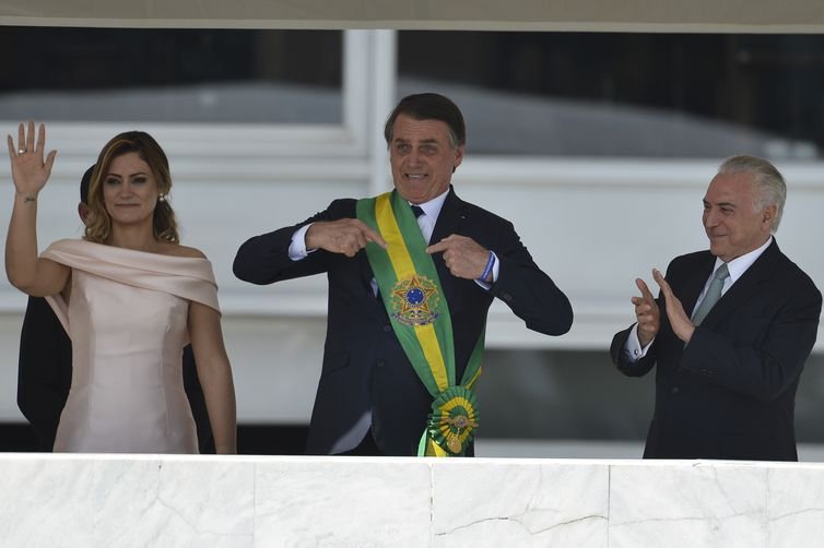 Posse de Jair Bolsonaro como presidente.  Ele aponta para a faixa no peitoral verde e amarela-Metrópoles