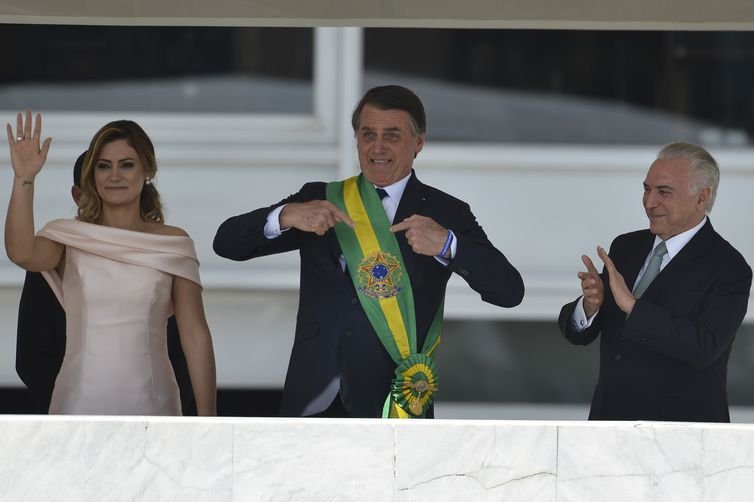 Posse de Jair Bolsonaro como presidente. Ele aponta para a faixa no peitoral verde e amarela-Metrópoles