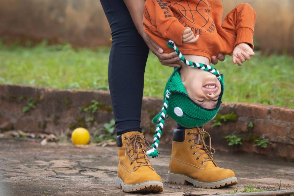criança sorrindo de cabeça para baixo