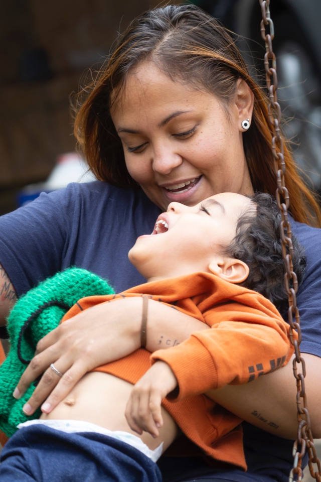 criança sorrindo em colo de mulher