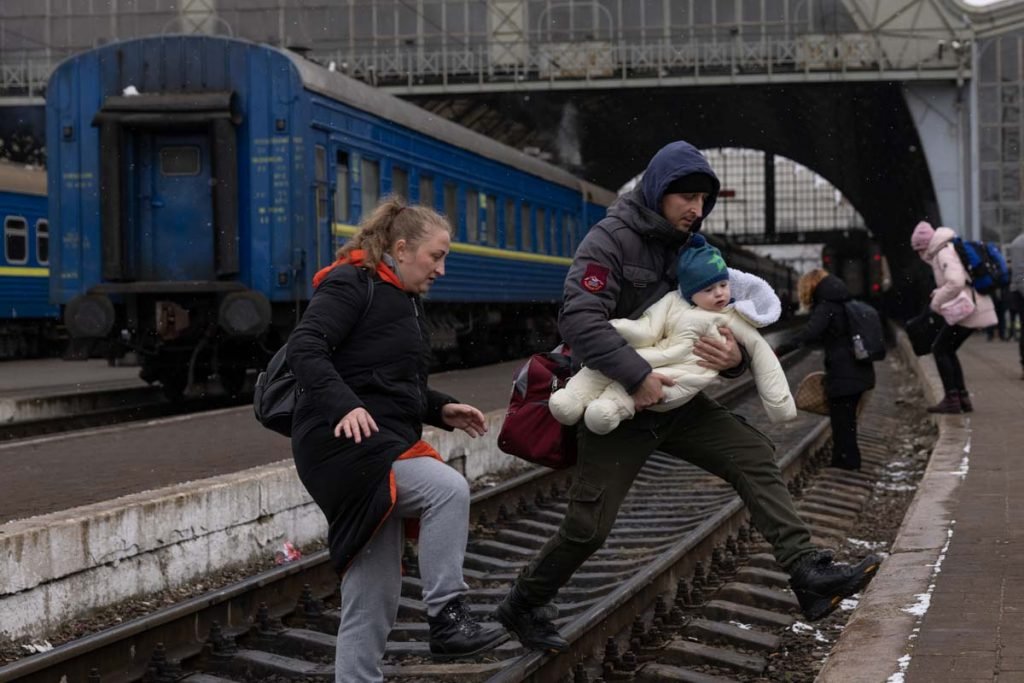 Uma família atravessa a linha férrea enquanto continua sua jornada no principal terminal de ônibus e trem em 05 de março de 2022 em Lviv, Ucrânia.  Mais de um milhão de pessoas fugiram ao país da Ucrânia após o ataque em grande escalada da Rússia a caminho da Polônia