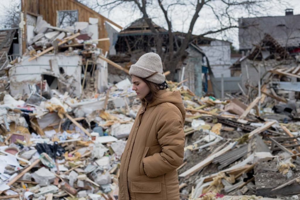 Residente local fica em frente aos escombros como resultado do bombardeio em 5 de março de 2022 em Markhalivka, Ucrânia