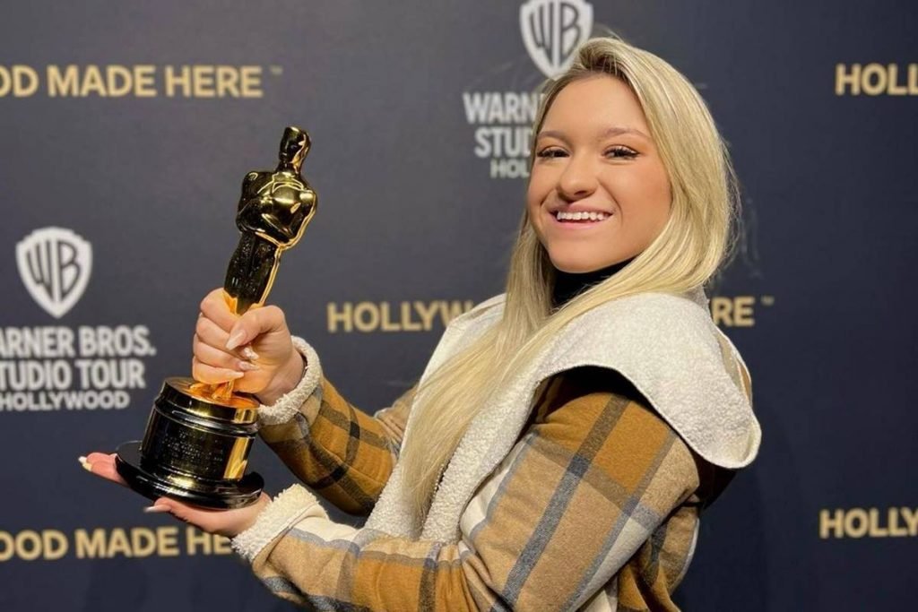 na foto vemos uma mulher loira com um oscar na mão