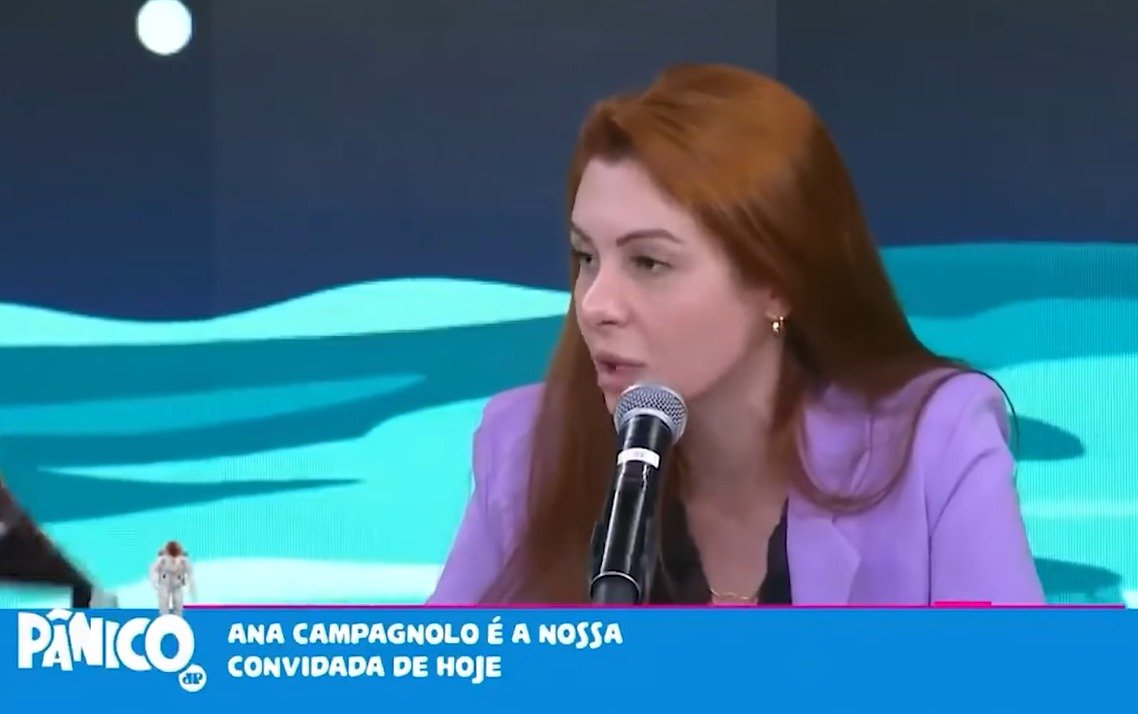 A deputada estadual por Santa Catarina Ana Campagnolo em entrevista no Programa Pânico. Ela tem cabelo liso e ruivo e fala ao microfone, usando roupa rosa - Metrópoles