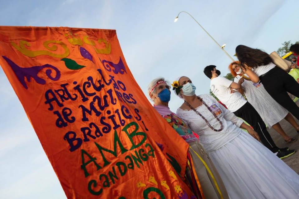 foto-pessoas-tiram-fotos-com-cartazes-manifestação-contra-machismo-racismo-lgbtfobia-esplanada-brasília-08032022