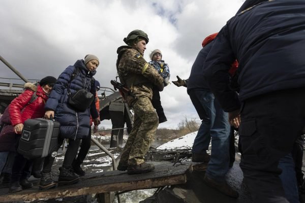 Em Irpin, na Ucrânia, civis atravessam apoio improvisado em ponte destruída por bombardeio russo para fugir da guerra - Metrópoles