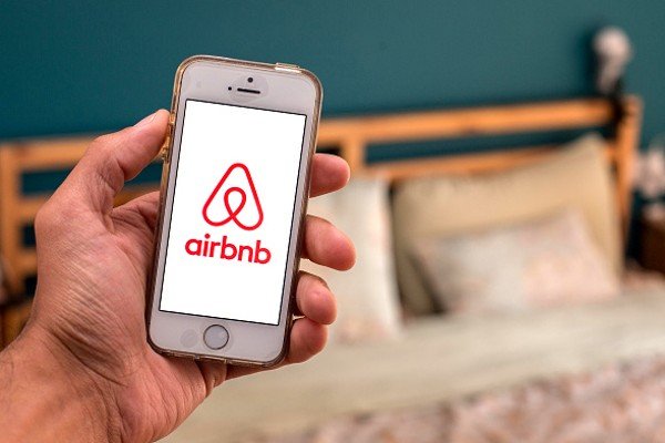 Pessoa mostra logomarca de Airbnb em aplicativo de celular-Metrópoles