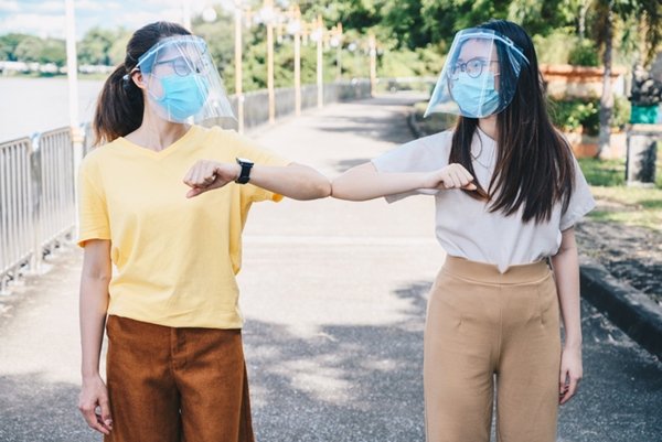 Mulheres usando mascaras e tocando os cotovelos - Metrópoles