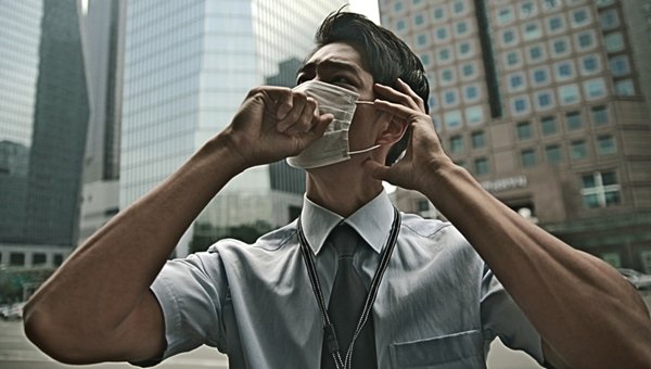 Foto homem usando mascara e tossindo - Metrópoles