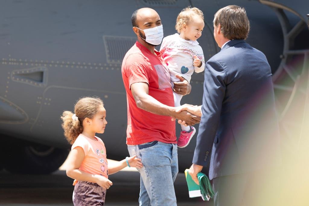 Um dos resgatados da guerra da Ucrânia, vindos da Polônia, leva as duas filhas e aperta a mão do presidente Bolsonaro - Metrópoles