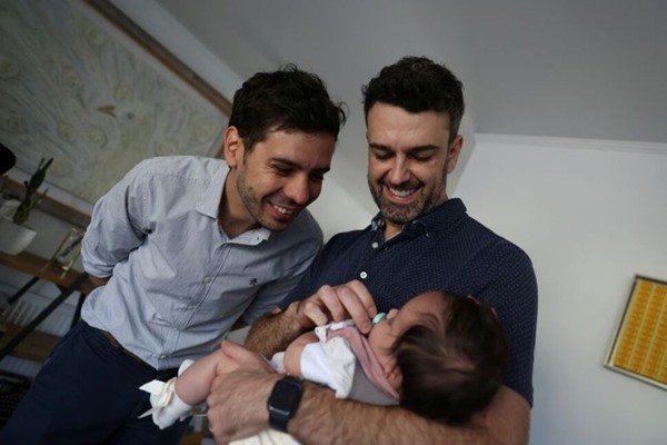 pais seguram filha no colo