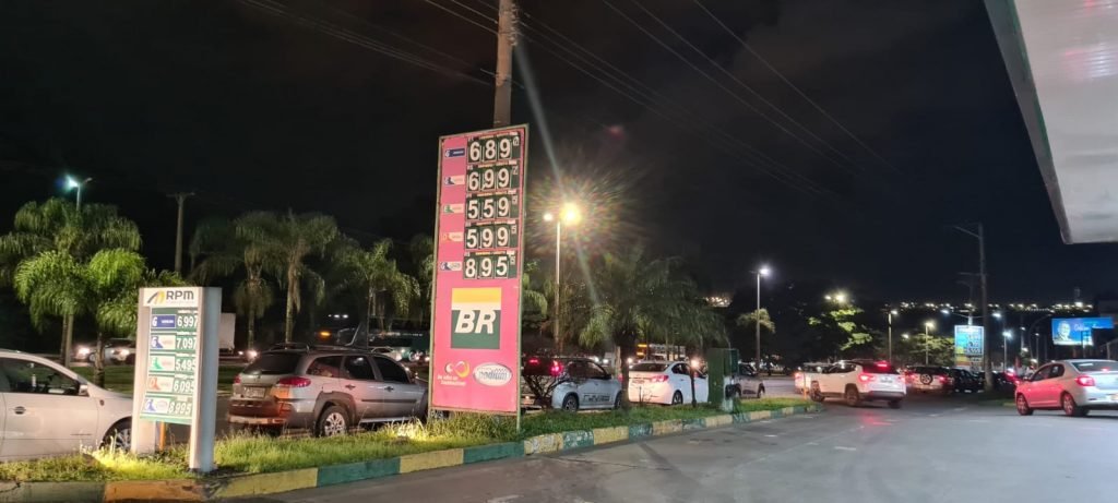 Fila de carros e placa em posto de gasolina