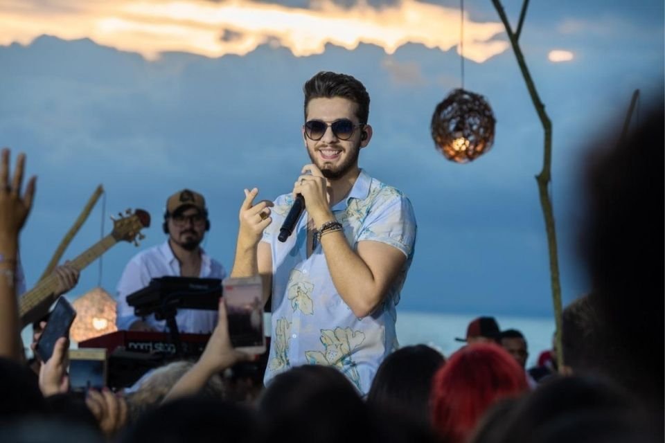 A imagem colorida mostra um show de Gustavo Mioto
