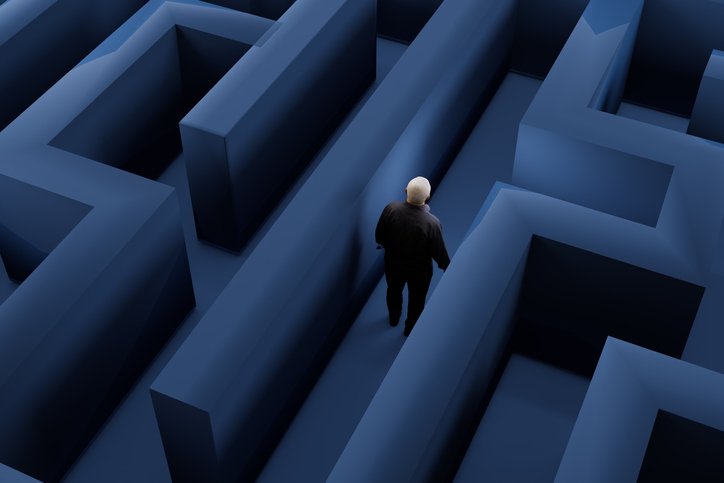 Person walking through a blue maze.  She wears black clothing and has white hair- Metropolises