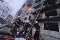 Bombeiros resgatam um civil de um prédio de apartamentos danificado que foi atingido por um ataque russo em Kiev, na Ucrânia