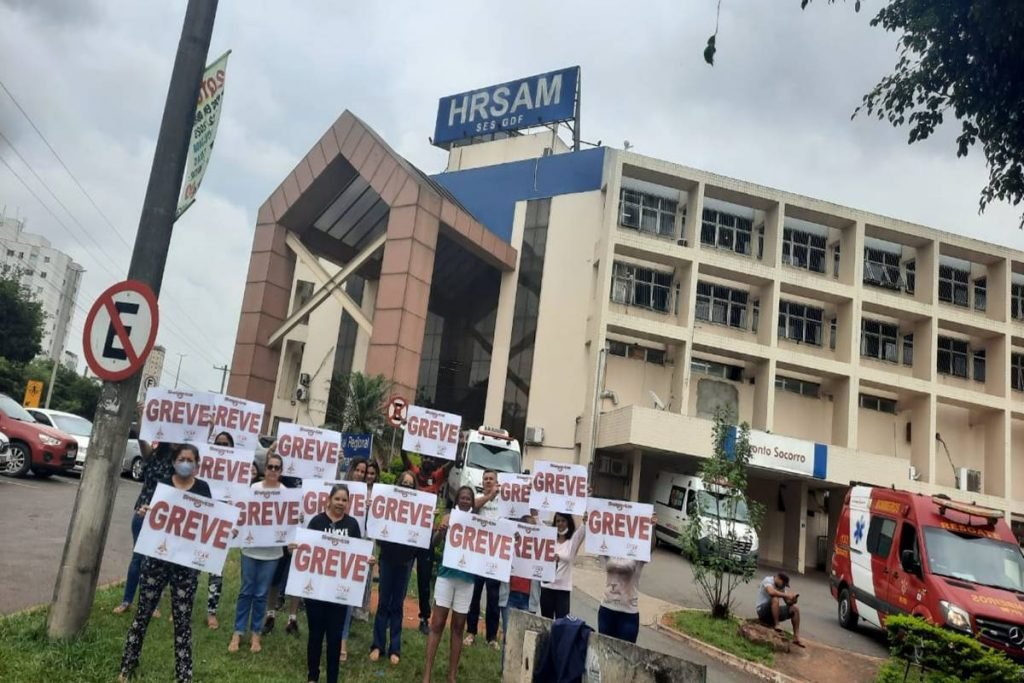 Trabalhadores seguram placa em frente ao hospital