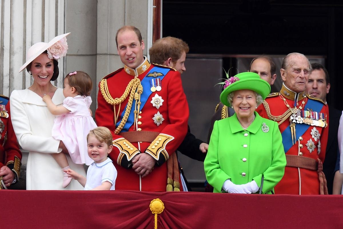 Foto colorida. Kate Middleton, príncipe William, rainha Elizabeth e príncipe Philip. Os homens estão com trajes militares