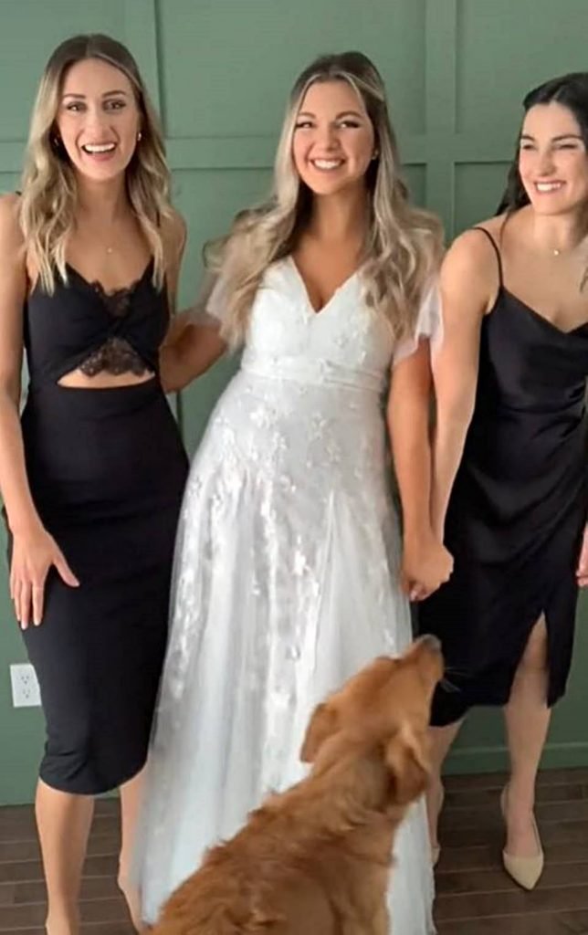 foto de três mulheres, sendo uma noiva no meio e um cachorro na frente dela