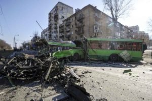 Soldado fica ao lado de um veiculo destruído por um míssil de cruzeiro derrubado pela força de defesa aérea ucraniana no bairro de Kurenivka, Kiev, capital da Ucrânia