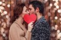 Casal se beijando com coração vermelho na frente