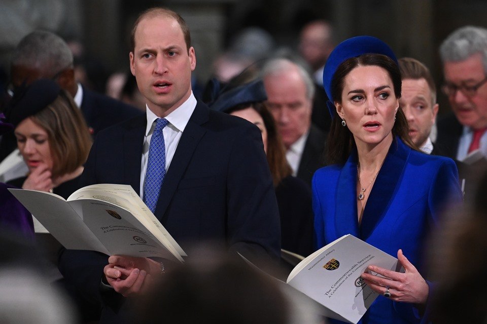 Foto colorida. Príncipe William e Kate Middleton em uma plateia