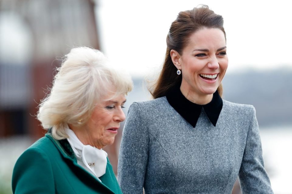 Foto colorida. Camilla Parker e Kate Middleton lado a lado, sorridentes