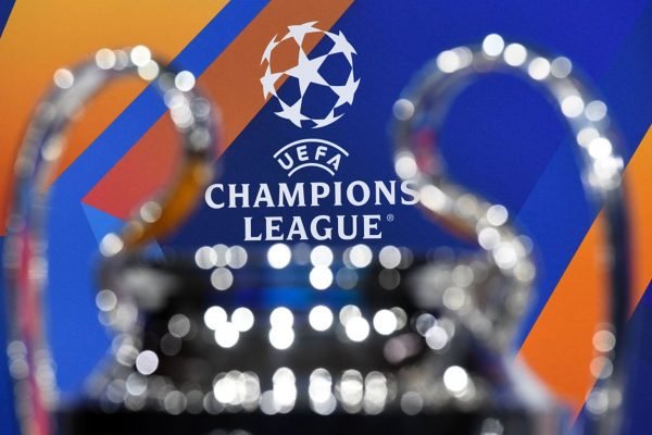 Taça da Champions League desfocada com fundo do banner do campeonato europeu - Metrópoles