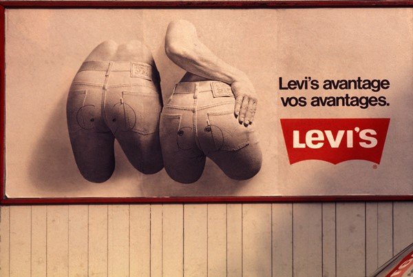 Outdoor com campanha publicitária da marca Levi's. Na foto é possível ver um homem e uma mulher usando calças jeans da marca.