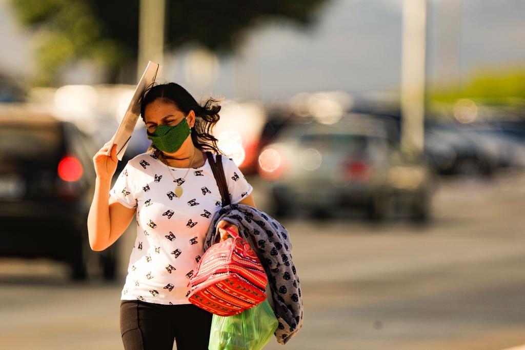 mulher se protege do calor na area central de Brasilia