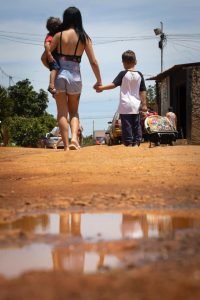 mulher e crianças andando em estrada de terra