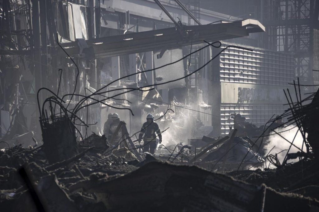 Foto de bombeiros ucranianos em meio aos escombros de shopping na capital, Kiev, após bombardeio de forças russas - Metrópoles