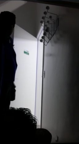 Homem parado perto da porta dentro de um quarto escuro