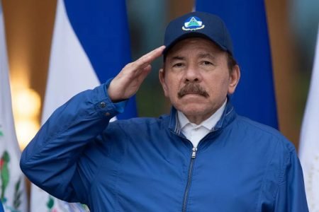 foto do presidente da Nicarágua batendo continência. Ele veste um casaco azul e usa um boné da mesma cor