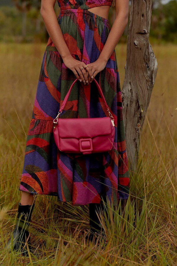 Na imagem com cor, bolsa e vestido em destaques na coleção da Renner
