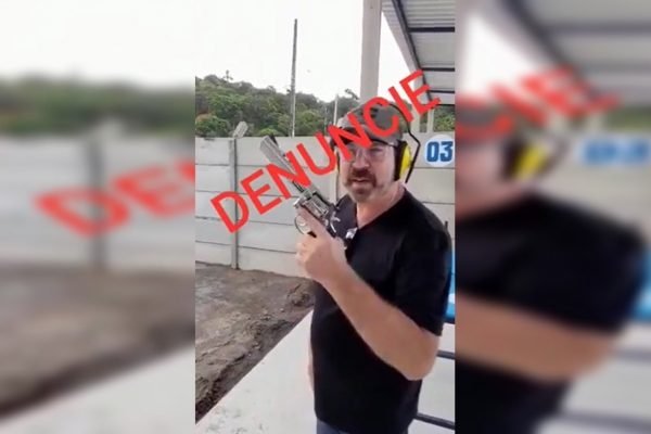 foto editada de um homem branco segurando uma arma. ele usa boné e camisa preta