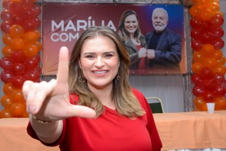 A deputada e pré-candidata à governadora em Pernambuco, Marília Arraes se filia ao Solidariedade. Ela faz um símbolo de L com os dedos e ao fundo vê-se um banner seu com o ex-presidente Lula e balões - Metrópoles