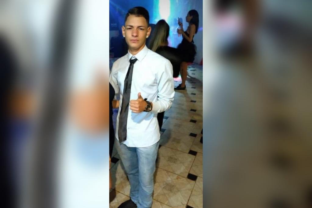 Jovem usando camiseta clara e gravata. Ele tem tatuagens no braço e mão - Metrópoles