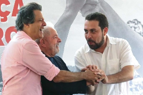 O ex-prefeito de SP Fernando Haddad (PT), o ex-presidente Lula e o líder do Movimento dos Trabalhadores Sem Teto (MTST) Guilherme Boulos (PSol) se cumprimentam em evento - Metrópoles