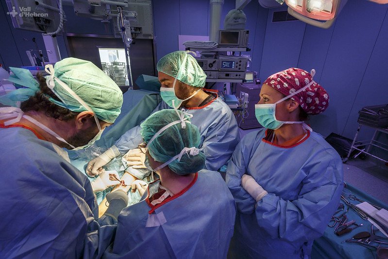 Imagem colorida onde uma equipe medica realiza cirurgia ortopédica