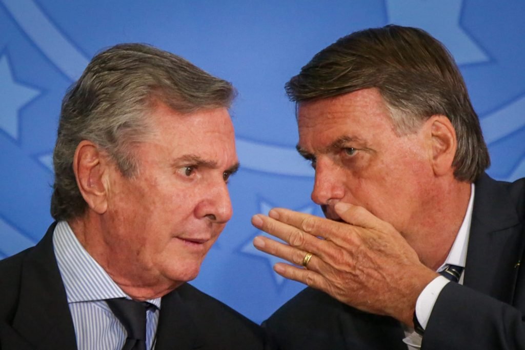 O senador Collor escuta Bolsonaro cochichar em seu ouvido em cerimônia no Planalto. Ele bota a mão na frente da boca. - Metrópoles