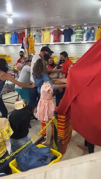 em meio a confusão, mulher com camisa azul é puxada