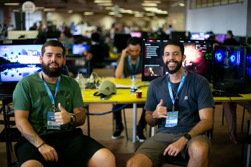 dois jovens olham para a câmera e levantam o polegar