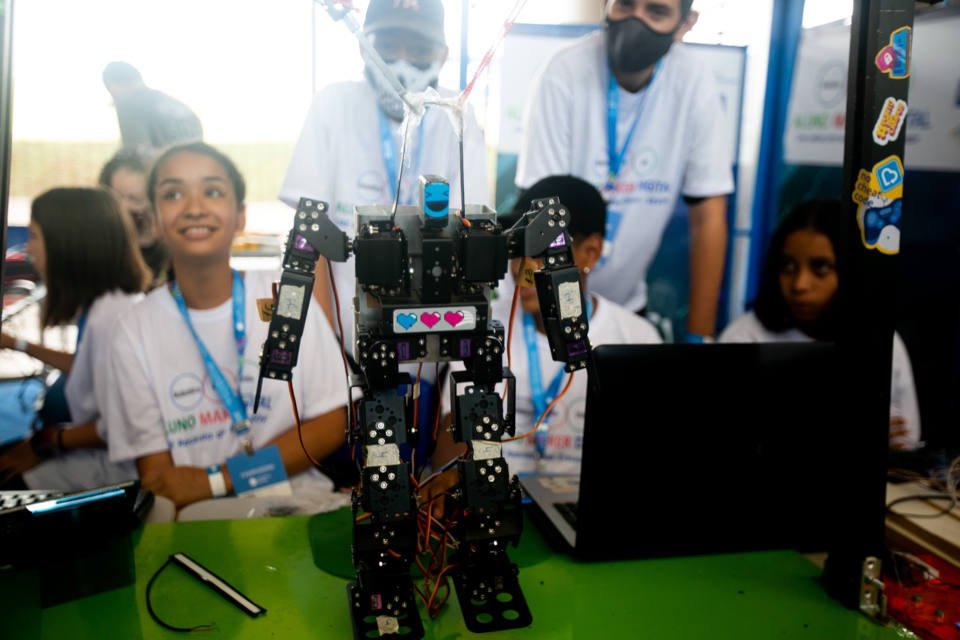 estudantes com robô em cima de uma mesa